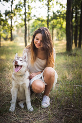 young caucasian female with siberian husky puppy in park