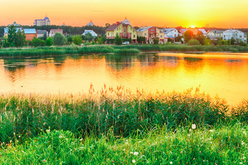 Fototapeta premium Sunset over the lake and houses.
