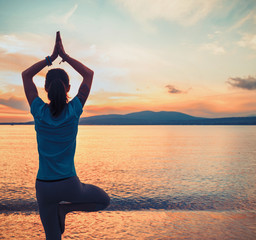 Woman doing yoga exercise in pose of tree