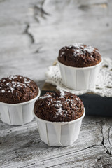 chocolate muffins on a light wooden surface, vintage style