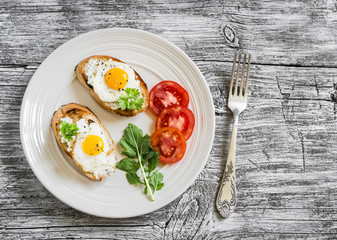 toast with soft cheese and quail eggs on a white plate on a light wooden background