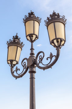The classic elegant street lampposts with blue sky background.