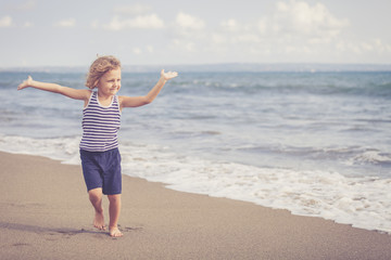 Portrait of little boy jumping on the beach