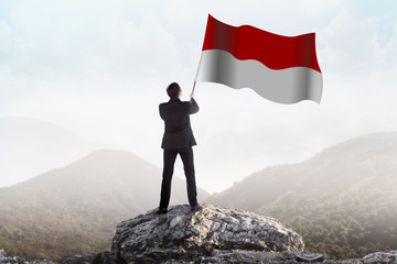 Successful man waving Indonesian flag