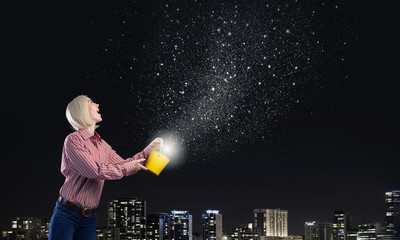 Woman splashing stars from bucket
