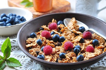 homemade granola with fresh blueberries, raspberries, raisins, milk and honey. Healthy Breakfast