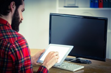Hipster businessman working on his tablet pc