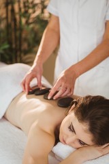 Obraz na płótnie Canvas Young woman getting a hot stone massage