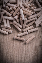 Variety of cylinder wooden dowel pins on wood board construction