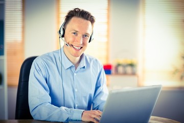 Obraz na płótnie Canvas Casual businessman using headset on a call