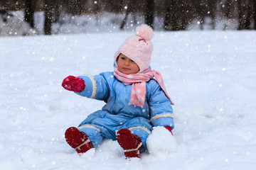 Fototapeta na wymiar cute little toddler girl in winter snow