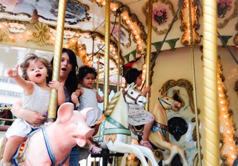 Madre con tres hijas en tiovivo