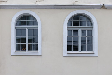 Two large, white arched windows in the building.