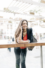Fototapeta premium Portrait of a beautiful young businesswoman standing outside usi