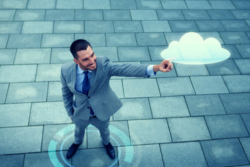 smiling businessman with cloud projection outdoors