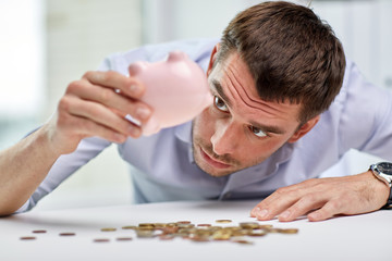 businessman with piggy bank and coins at office