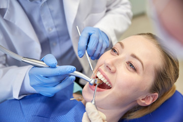 close up of dentist treating female patient teeth