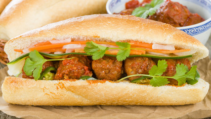 Banh Mi Xiu Mai - Vietnamese sandwich with meatballs in tomato sauce, do chua (radish and carrot pickle), cucumber and coriander.
