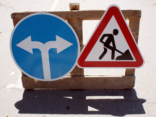 Two road signs low wooden stand