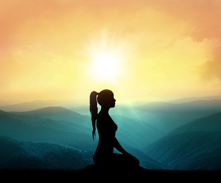Yoga and meditation. Silhouette of woman in mountains.