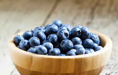 Fresh blueberry in a wooden bowl, selective focus