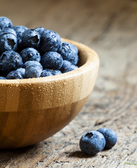 Fresh blueberry in a wooden bowl, selective focus