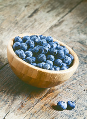 Fresh blueberry in a wooden bowl, selective focus