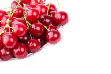 fresh cherries in a white ceramic plate isolated on white background