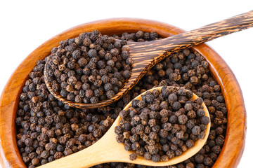 black pepper on wooden spoon with wooden plate isolated on white background.