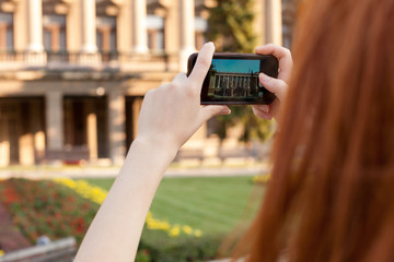 young girl taking pictures of the city