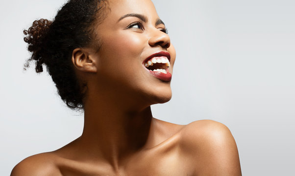 Happy black woman with bare shoulders on a white background