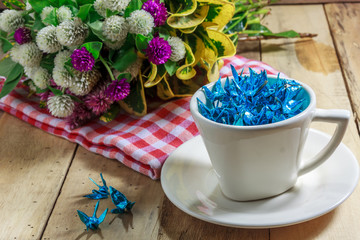 The blue bird paper in the cup and flower also red cloth on the