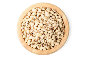 white cowpea beans in the wooden plate, top view