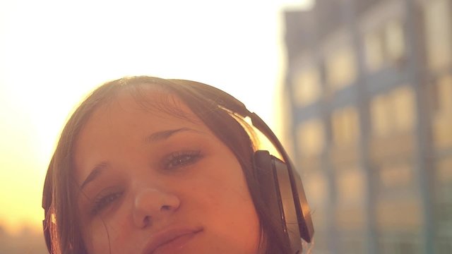 Slow motion of Young woman listening to music in headphones at