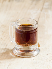 light beer in a little old-fashioned mug on old wooden table, se