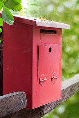 Red mailbox with green nature background