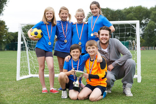 Victorious School Soccer Team With Medals And Trophy