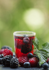 Tea with forest berries on a green natural background, selective