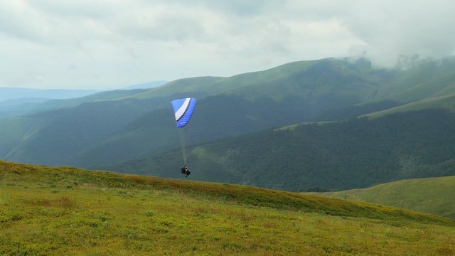 4k,
Paraglider flying high in the mountains