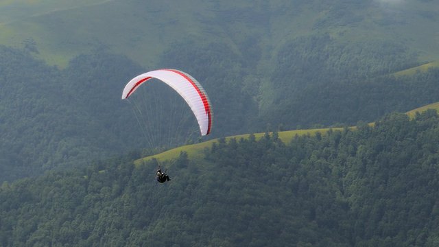 4k,
Paraglider flying high in the mountains