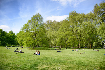 People lying on grass relaxing in a London Park