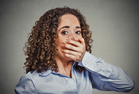 scared young woman covering with hand her mouth