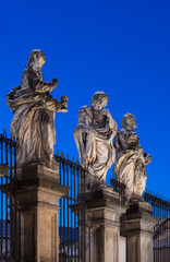 Baroque sculptures of the Apostles on the plinths in front of the Saints Peter and Paul church in Krakow illuminated in blue hour