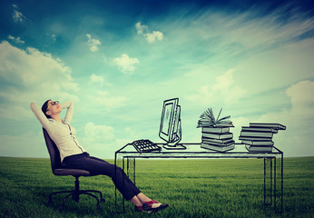 young businesswoman relaxing sitting in the office in the middle of a green meadow. Stress free...