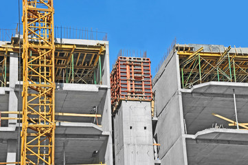 Crane and building construction site against blue sky