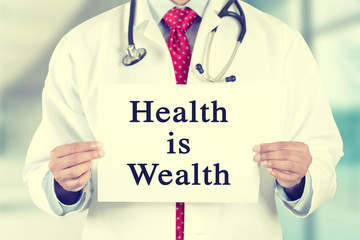 doctor hands holding white card sign with health is wealth text message
