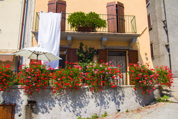Fototapeta na wymiar Vagli Sotto: balcone di una casa con vasi di fiori