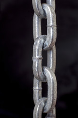 Fototapeta premium part of metal chrome chain against dark background