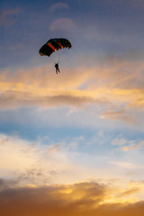 Skydiver On Colorful Parachute In Sunny Sky