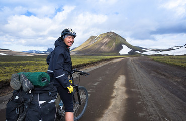 Happy biker on backdrop of volcanic mountains in Iceland